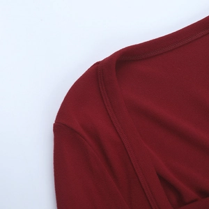 Dettaglio dello scollo quadrato e della spalla di un abito aderente in maglia rosso vino