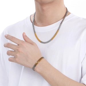 Two-tone silver and gold Cuban link chain necklace and bracelet set worn by a model