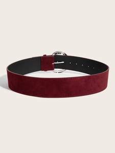Détail d'une ceinture large bordeaux en texture suédine avec une boucle ronde argentée