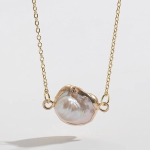 Detailed view of an irregular baroque pearl pendant with 14K gold plated chain