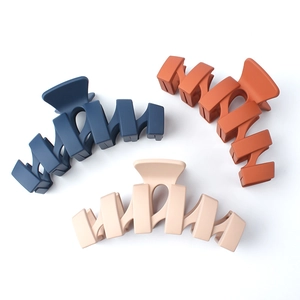 Matte wavy hair claw clips in navy, caramel, and beige colors on a white background