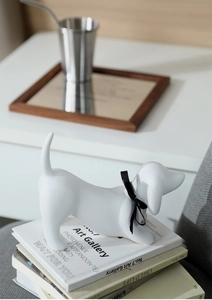 Artistic white ceramic dachshund sculpture on books for minimalist home decor