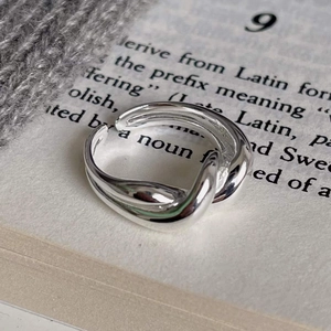 Macro shot of minimalist S925 sterling silver twisted open ring on an aesthetic background