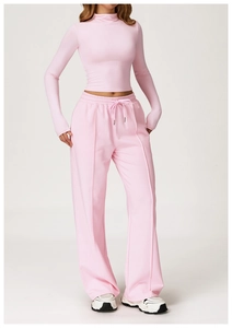 Detail of pink tight high-neck yoga top and drawstring wide-leg pants with side stitching