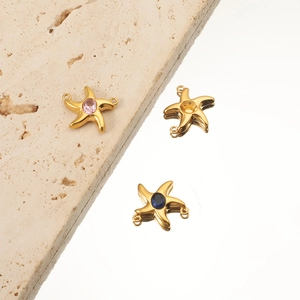 Detailed macro view of 18K gold plated starfish pendants with pink and blue crystal inlay
