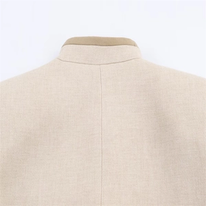 Gros plan du haut beige à épaulettes avec détail de col camel et texture fine