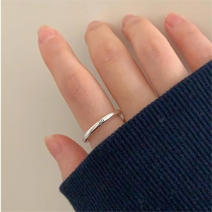 Detailed close-up of a minimalist 925 silver smiley face ring worn on finger
