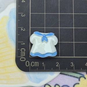 Detail shot of a 2cm blue and white sailor uniform resin charm on a measuring mat