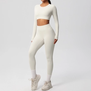Detail of white long sleeve crop top and high waist yoga leggings with ribbed texture