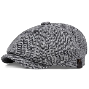 Classic newsboy cap with grey herringbone pattern and side leather tag detail