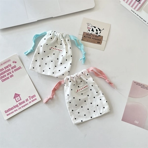 Detailed view of polka dot drawstring pouches in breathable cotton linen with fabric labels