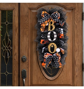 Detail of Halloween Boo door wreath with orange ribbons and cobweb patterns on wood