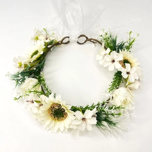 Detailed top view of a sunflower wreath headband with white daisy petals and green leaves