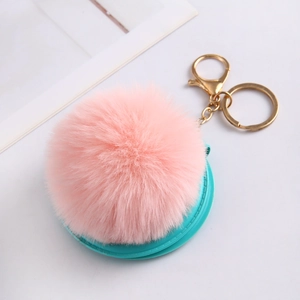 Close-up of pink faux rabbit fur ball keychain with blue folding makeup mirror