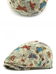 Close-up of beige jacquard flat cap with colorful woven butterfly patterns and textures