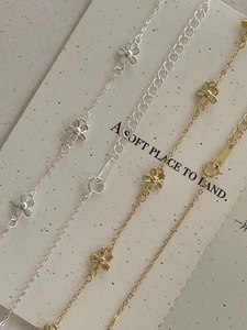 Close-up of gold and silver fine chain necklaces with delicate floral petal charms