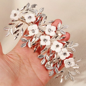 Detail of silver bridal hair clip with white floral petals and sparkling crystal accents