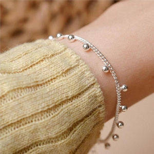 Detailed shot of S925 sterling silver beaded bracelet styled with a knit sleeve