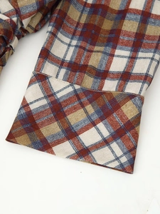 Close-up of long sleeve cuff showing plaid pattern and woven texture on a mini dress