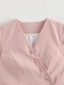 Detail shot of pink V-neck vest featuring woven fabric texture and matching four-hole buttons