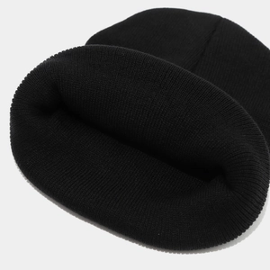 Close-up of black ribbed knit beanie showing high-quality texture and warm elastic material