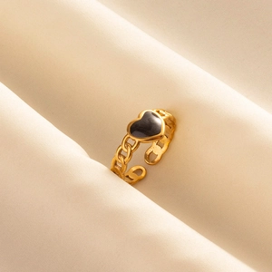 Minimalist gold stainless steel chain ring with black hollow heart centered on fabric