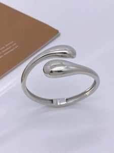 Detail view of silver teardrop open cuff bracelet with high polished metallic finish