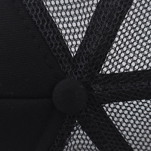 Détail macro du bouton supérieur et du tissu en maille noire respirante de cette casquette