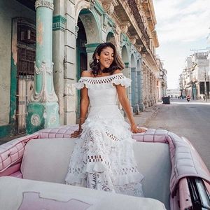 Weißes schulterfreies Spitzenkleid mit Volants auf einem rosa Vintage-Cabriolet