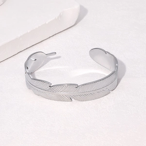Macro detail of the silver feather texture and adjustable opening on the metal bracelet