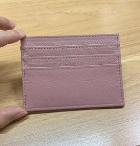 Close-up of pink litchi grain leather card holder featuring multiple functional slots