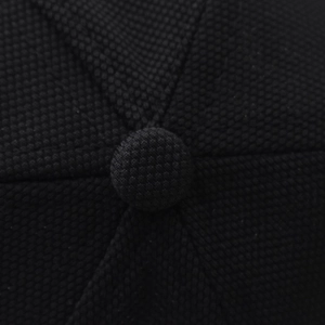 Macro shot of black baseball cap crown showing textured mesh fabric and top button detail