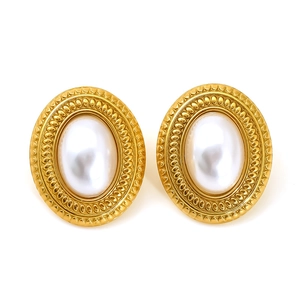 Retro golden oval pearl stud earrings with textured relief edges on a white background
