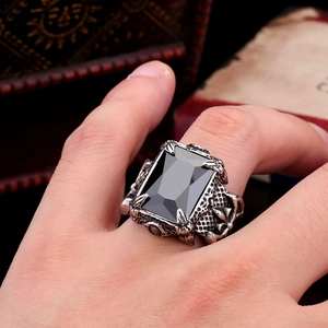 Detailed close-up of a vintage gothic men's ring with a black gemstone on a wooden box