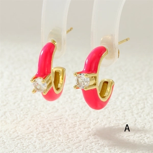 Detail of pink enamel J-hoop earrings with gold plating and sparkling zircon stone