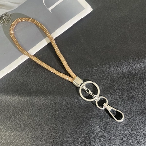 Macro detail of champagne gold rhinestone lanyard with polished silver lobster clasp hardware