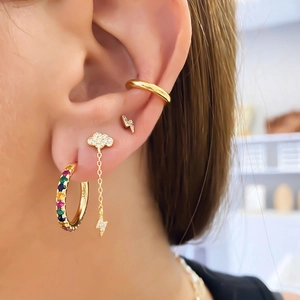 Detailed view of gold earrings set featuring zircon clouds, lightning studs, and ear cuffs