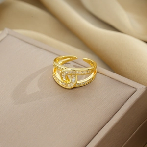 Luxurious gold-tone crisscross ring with sparkling rectangular zircons on jewelry box