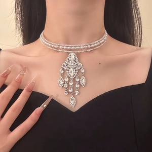 Close-up of a silver-tone three-layer choker with sparkling rhinestone fringe and pearls