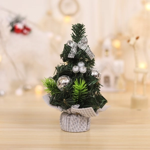 Mini green desktop Christmas tree with silver bows and festive base decoration