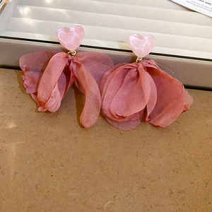 Detail shot of pink mesh flower heart earrings featuring resin and pearl accents