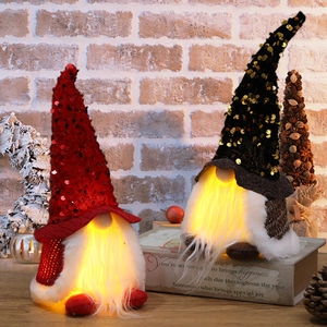 Lighted Christmas gnomes with sequins and warm LED lights on a wooden desk setup