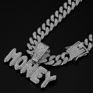 Macro shot of silver Cuban chain necklace with iced out MONEY pendant and crystal buckle