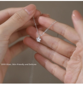 Detailed view of S999 silver star necklace held by hand showing delicate zircon pendant