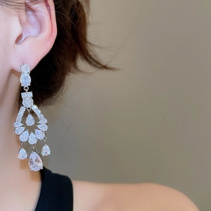 Close-up of elegant silver drop earrings with zircon tassels on model for formal events