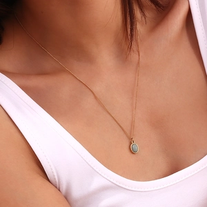 Close-up of a mini oval green aventurine stone pendant on an 18K gold stainless steel chain
