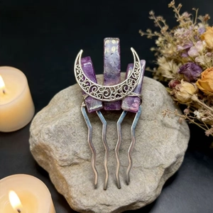Detailed macro view of handmade purple crystal moon hair comb on natural rock