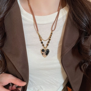 Close-up of heart-shaped leopard print resin pendant necklace with tiger eye stone beads
