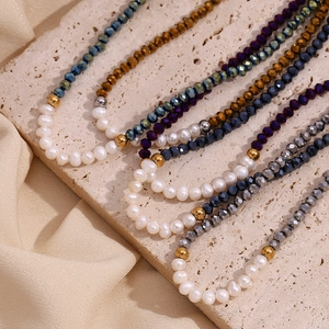 Macro view of freshwater pearls and faceted colorful crystal beads on a silk fabric