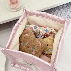 Detailed macro view of pink quilted storage basket with lace bow and inner lining